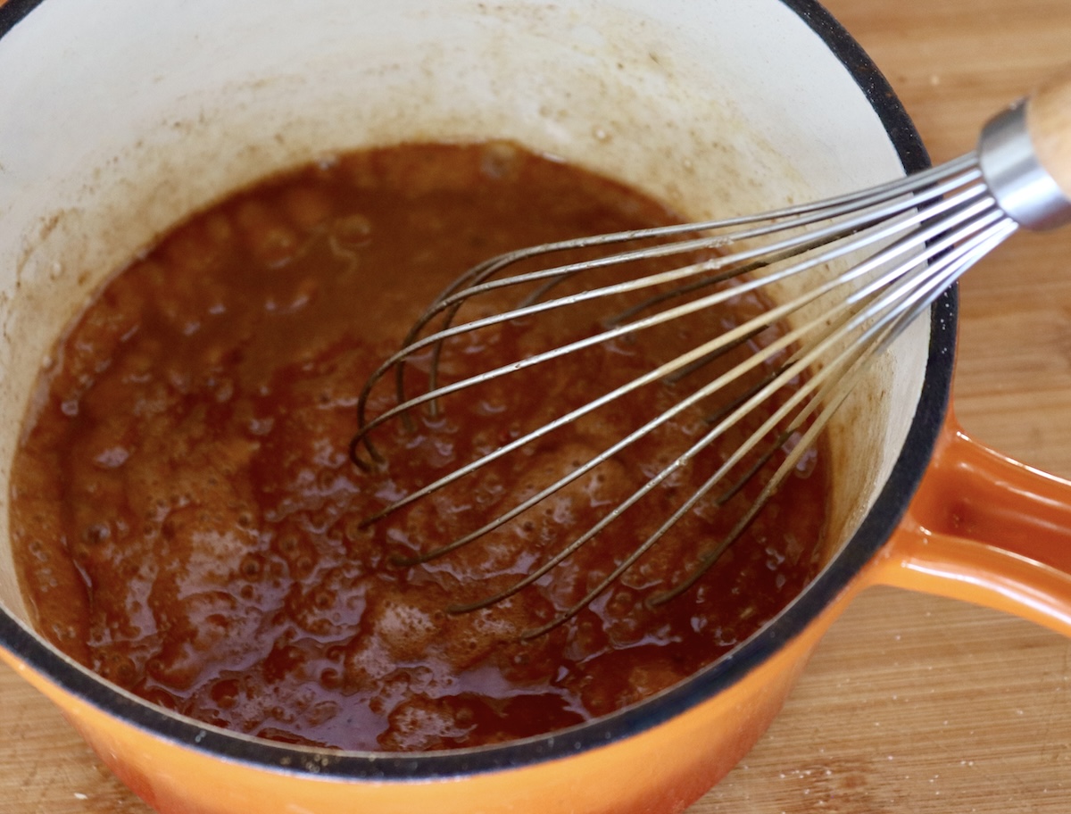 Pull-Apart French Toast Egg, sugar and cinnamon mixed together in an orange sauce pan with a whisk.