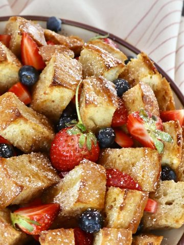 Whole, round French bread loaf cut into squares, baked and filled with fresh blueberries and strawberries.