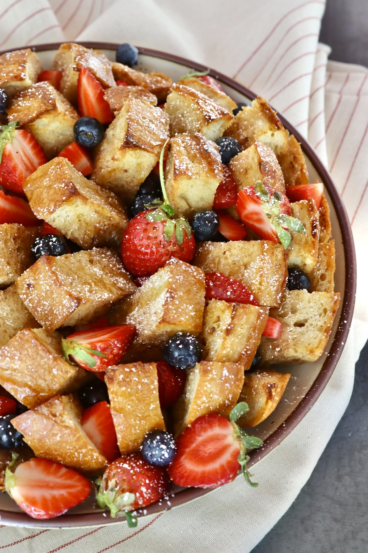 Pull-Apart French Toast Whole, round French bread loaf cut into squares, baked and filled with fresh blueberries and strawberries.