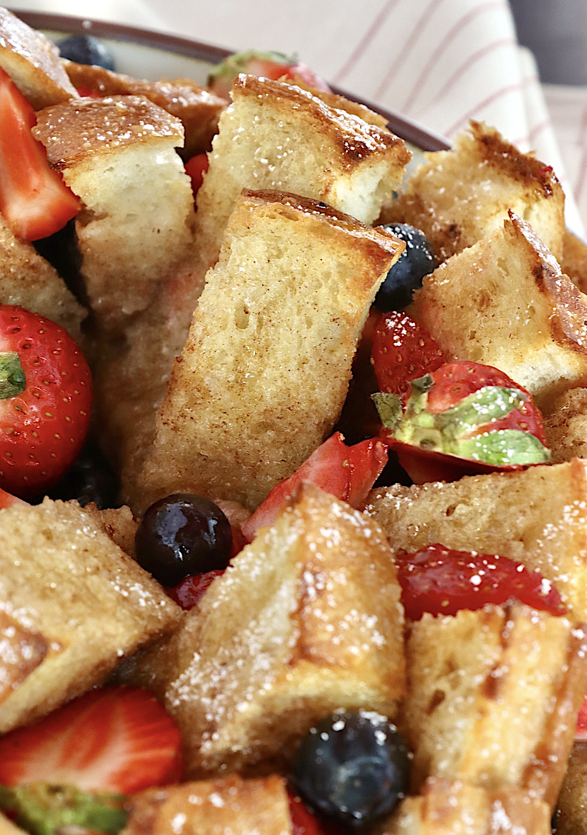 Pull-Apart French Toast Close up of pull apart French toast right out of the oven with fresh chopped berries.