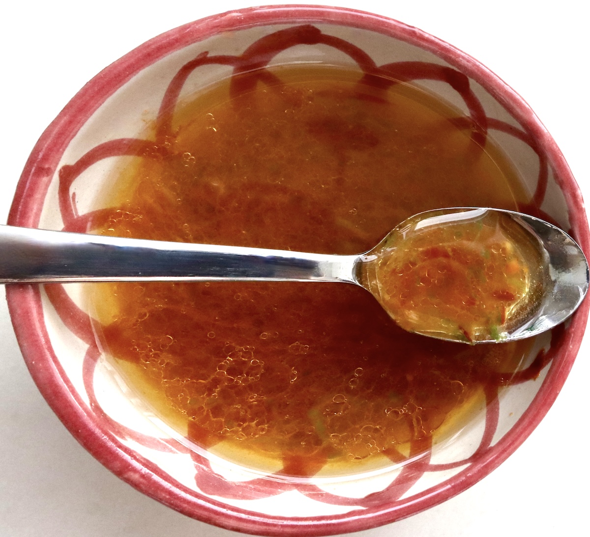 Lime-Chile-Grilled-Watermelon Lime-chile marinate in a red and white painted small bowl with a silver spoon.