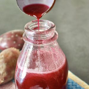 Prickly Pear syrup in a bottle with a small ladle adding more at the top.