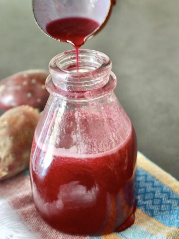 Prickly Pear syrup in a bottle with a small ladle adding more at the top.