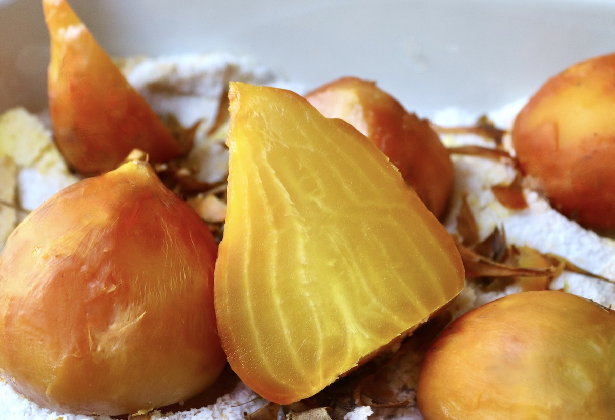Salt-roasted golden beets, with one large one sliced in  half.